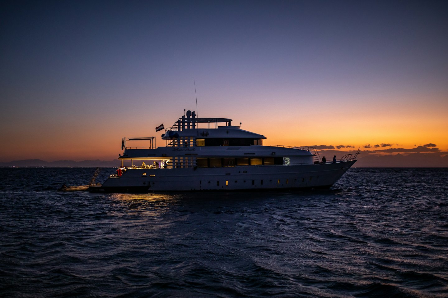 Un superyacht bianco naviga in mare al tramonto.