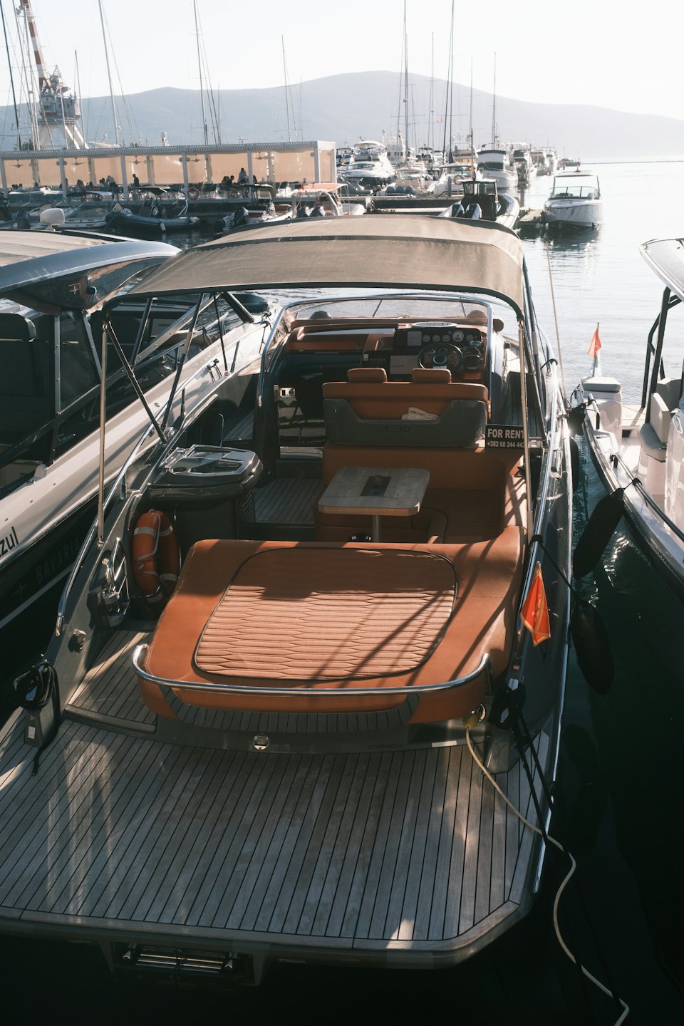 Lussuoso yacht a motore ormeggiato in un vivace porto turistico.