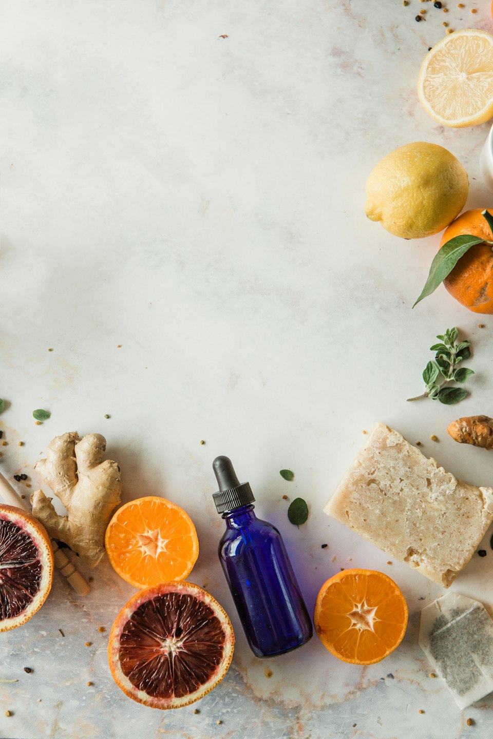 Prodotti naturali per il benessere e agrumi disposti su una superficie di marmo.
